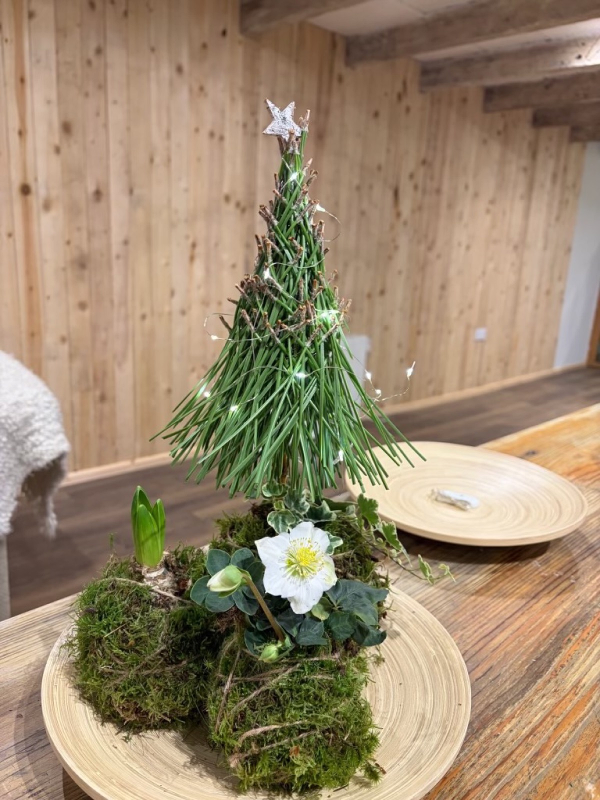 A miniature Christmas tree made from foliage and flowers