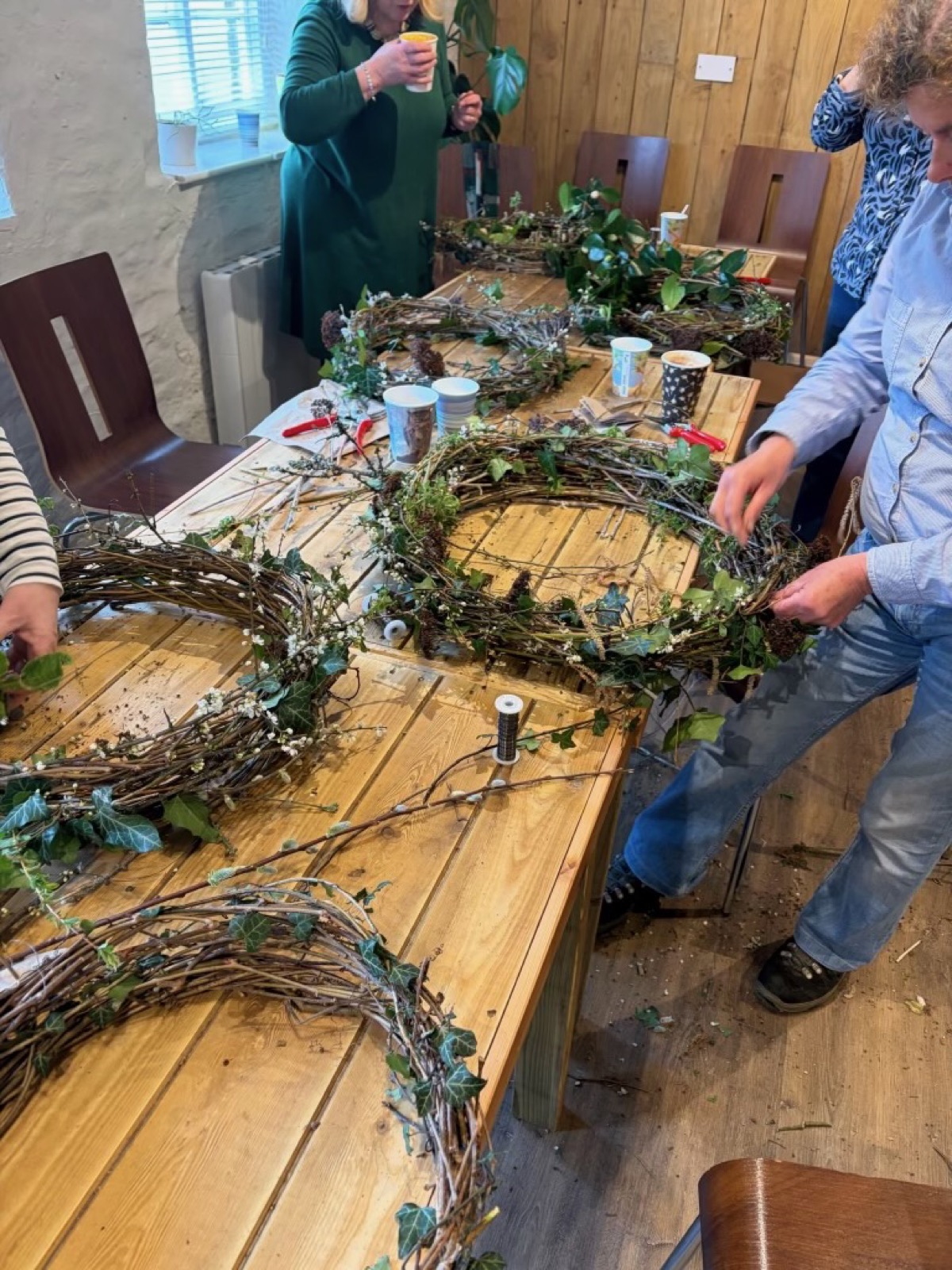 Making foliage wreaths around the workshop table