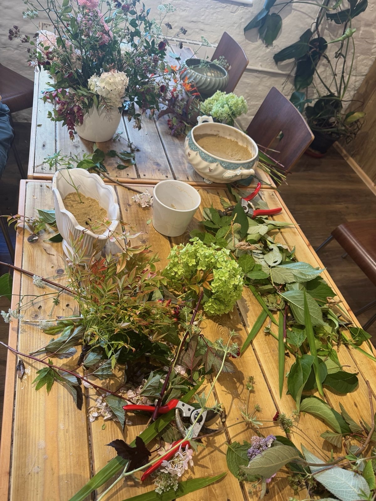 Flowers and foliage gathered around a workshop table